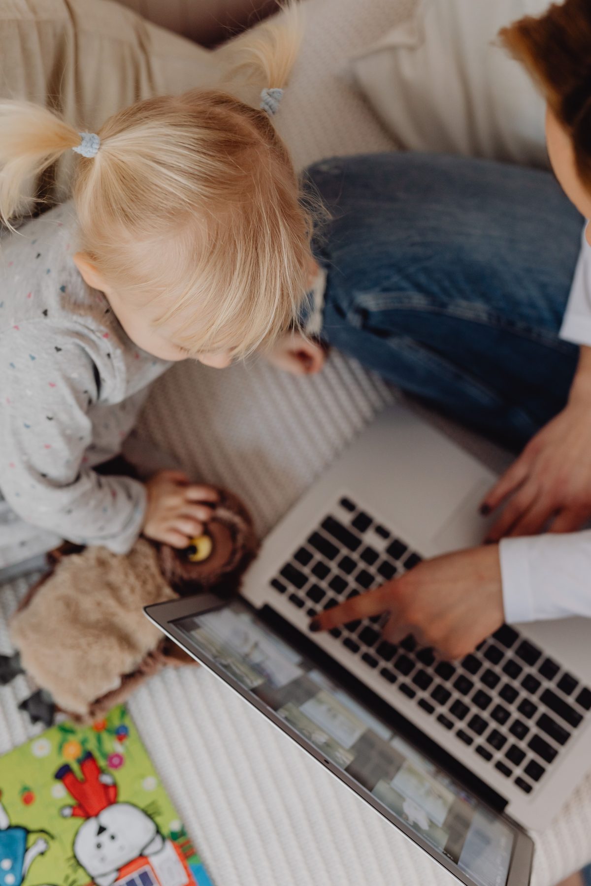 Une maman et sa fille regardent un ordinateur portable ensemble, à la maison